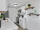 Modern kitchen with white countertops, stainless steel appliances, and wooden shelving at 1915 Quitman St, North Charleston, SC 29405