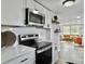 Well-equipped kitchen with stainless steel appliances, white cabinets, and open layout to living room at 1915 Quitman St, North Charleston, SC 29405