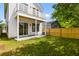 Manicured backyard featuring a privacy fence, lush green lawn, and covered patio with a deck above at 1989 Groveland Ave, North Charleston, SC 29405