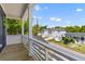 A picturesque neighborhood view from a private balcony featuring a wooden deck and white railing at 1989 Groveland Ave, North Charleston, SC 29405