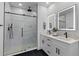 A modern bathroom features dual sinks, lighted mirrors, and a frameless glass shower with a rain shower head at 1989 Groveland Ave, North Charleston, SC 29405