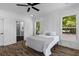 A modern bedroom features wainscoting, a ceiling fan, an ensuite bathroom, and views from two windows at 1989 Groveland Ave, North Charleston, SC 29405