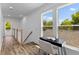 A sunlit hallway nook has a desk with an open book and beautiful views from two large windows at 1989 Groveland Ave, North Charleston, SC 29405
