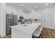 Bright kitchen featuring an island with barstool seating, pristine white cabinetry, and stainless steel appliances at 1989 Groveland Ave, North Charleston, SC 29405