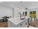 Open kitchen design featuring an island with sink, modern pendant lighting, stainless appliances, and an adjacent living area at 1989 Groveland Ave, North Charleston, SC 29405