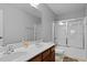 Bathroom featuring a double sink vanity with wood cabinetry and a shower-tub combo with glass doors at 200 Commencement Blvd, Ladson, SC 29456