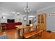 Bright dining area with hardwood floors, decorative chandelier, and open view to the staircase and living area at 200 Commencement Blvd, Ladson, SC 29456