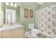 Light green bathroom featuring a single sink vanity and shower with floral curtain at 216 W Arctic Ave # 9, Folly Beach, SC 29439