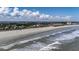 Expansive view of beach and surf with condo in view along the shore in the distance at 216 W Arctic Ave # 9, Folly Beach, SC 29439