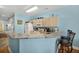 Stylish kitchen with breakfast bar, white appliances, light cabinets and modern barstool seating at 216 W Arctic Ave # 9, Folly Beach, SC 29439