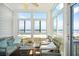 Bright sunroom with ocean views and cozy seating at 216 W Arctic Ave # 9, Folly Beach, SC 29439