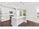 This gorgeous kitchen features white cabinets, stainless appliances, a quartz island, and modern lighting at 2200 Hamlin Sound Cir, Mount Pleasant, SC 29466