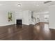 Bright living room featuring hardwood floors, a fireplace, and access to stairs leading to the upper level at 2200 Hamlin Sound Cir, Mount Pleasant, SC 29466