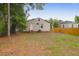 View of the home's rear exterior with a spacious backyard, a small deck and mature trees at 2350 Kent Ave, North Charleston, SC 29405