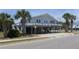 Two-story beach house featuring a wooden deck and ground-level parking and entertainment area at 2401 Palmetto Blvd, Edisto Island, SC 29438