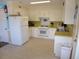Functional kitchen featuring white appliances, cabinets, and countertops with neutral flooring at 2401 Palmetto Blvd, Edisto Island, SC 29438