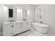 Bright bathroom featuring a double vanity with a marble countertop and a standalone soaking tub by a window at 2449 Daniel Island Dr, Daniel Island, SC 29492