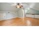 Spacious bonus room features light blue walls, wood flooring, a ceiling fan, and a wet bar with white cabinets at 2449 Daniel Island Dr, Daniel Island, SC 29492
