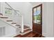 Bright entryway with hardwood floors, white staircase, and a beautiful wooden front door at 2449 Daniel Island Dr, Daniel Island, SC 29492