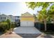 Two-car garage with a yellow exterior, featuring an adjacent driveway and well-maintained landscaping at 2449 Daniel Island Dr, Daniel Island, SC 29492