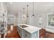 Gourmet kitchen boasts an island with cooktop, stylish pendant lights, and a cozy window bench seating area at 2449 Daniel Island Dr, Daniel Island, SC 29492