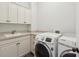 Functional laundry room equipped with modern washer and dryer units and ample cabinetry at 2449 Daniel Island Dr, Daniel Island, SC 29492