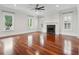 Living room featuring hardwood floors, a fireplace with white mantle, and large windows with plantation shutters at 2449 Daniel Island Dr, Daniel Island, SC 29492