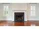 Elegant fireplace with white mantle and black hearth with large windows on either side at 2449 Daniel Island Dr, Daniel Island, SC 29492