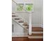 Elegant staircase with wooden steps, white railings, and natural light filtering through nearby windows at 2449 Daniel Island Dr, Daniel Island, SC 29492