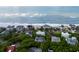 Aerial view of beachfront homes nestled between lush greenery and ocean waves, perfect for coastal living and enjoying the ocean breeze at 26 Beachwood East, Isle of Palms, SC 29451