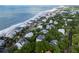 Picturesque aerial view of a coastal community with stunning homes, lush greenery, and the serene ocean stretching to the horizon at 26 Beachwood East, Isle of Palms, SC 29451