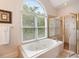 Bathroom featuring a soaking tub with a shower and a large window, providing natural light at 26 Beachwood East, Isle of Palms, SC 29451