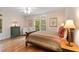 Bedroom with hardwood floors, a large window with a backyard view, and decorative lamps at 26 Beachwood East, Isle of Palms, SC 29451