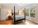 Cozy bedroom with a four-poster bed, hardwood floors, and large windows for natural light at 26 Beachwood East, Isle of Palms, SC 29451