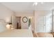 Bright bedroom with a cream-colored walls, hardwood floors, ceiling fan, and doorways to the bathroom at 26 Beachwood East, Isle of Palms, SC 29451