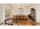 Formal dining room with chandelier, hardwood floors, wine storage, and large windows at 26 Beachwood East, Isle of Palms, SC 29451