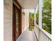 Welcoming front porch with a stylish wood door, overhead lighting, and a charming view of the surrounding lush greenery at 26 Beachwood East, Isle of Palms, SC 29451