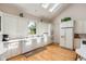 Bright kitchen with white cabinets, skylight, modern appliances, and hardwood floors at 26 Beachwood East, Isle of Palms, SC 29451