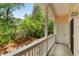 Inviting outdoor porch featuring a white railing, lush greenery, and ample space for relaxing and enjoying the peaceful surroundings at 26 Beachwood East, Isle of Palms, SC 29451