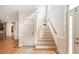 Bright staircase with wood steps, white risers, and decorative trim, offering an elegant transition between floors in the home at 26 Beachwood East, Isle of Palms, SC 29451