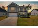 Charming two-story home with a well-maintained lawn and attached two-car garage during sunset at 261 Celestial Blvd, Summerville, SC 29486