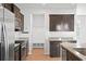 Kitchen has stainless steel appliances, granite countertops, dark wood cabinetry and a utility nook with hooks and storage at 261 Celestial Blvd, Summerville, SC 29486