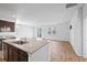 Open-concept kitchen with granite countertops, stainless steel appliances, dark cabinets, and wood floors flowing into the living area at 261 Celestial Blvd, Summerville, SC 29486