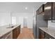A modern kitchen with stainless steel appliances, granite countertops, dark wood cabinetry, and a large island at 261 Celestial Blvd, Summerville, SC 29486