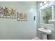 Elegant half bathroom features a pedestal sink and decorative artwork at 300 Saxony Loop, Summerville, SC 29486