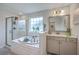 Modern bathroom with soaking tub, walk-in shower, vanity, and decorative plants on display at 300 Saxony Loop, Summerville, SC 29486