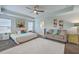 Spacious bedroom featuring a ceiling fan, a cozy seating area, and plush white carpet at 300 Saxony Loop, Summerville, SC 29486