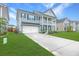 Beautiful two-story home boasts a manicured lawn, double porch, and convenient attached garage at 300 Saxony Loop, Summerville, SC 29486