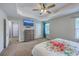 Carpeted bedroom with tray ceilings, ceiling fan, and a view to the attached bathroom at 3055 Nantuckett Ave, North Charleston, SC 29420