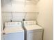 Bright laundry area featuring a washer, dryer, and wire shelving at 311 Dupont Way, Summerville, SC 29485